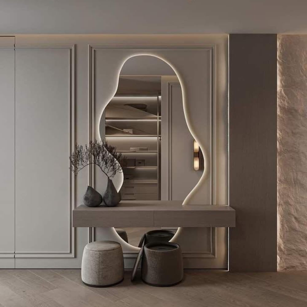 Modern interior design with a mirror, shelf, and decorative items against a neutral wall.