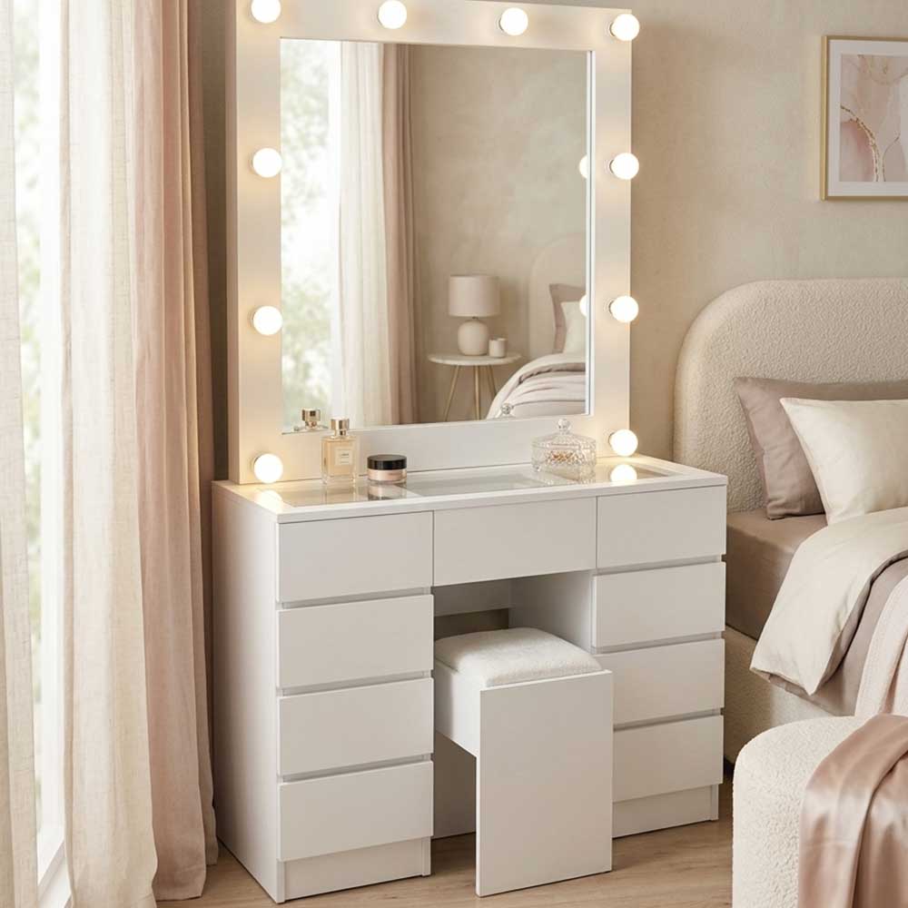 White vanity table with mirror and lights in a bedroom setting