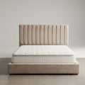 Beige bed with tufted headboard and mattress on a plain background