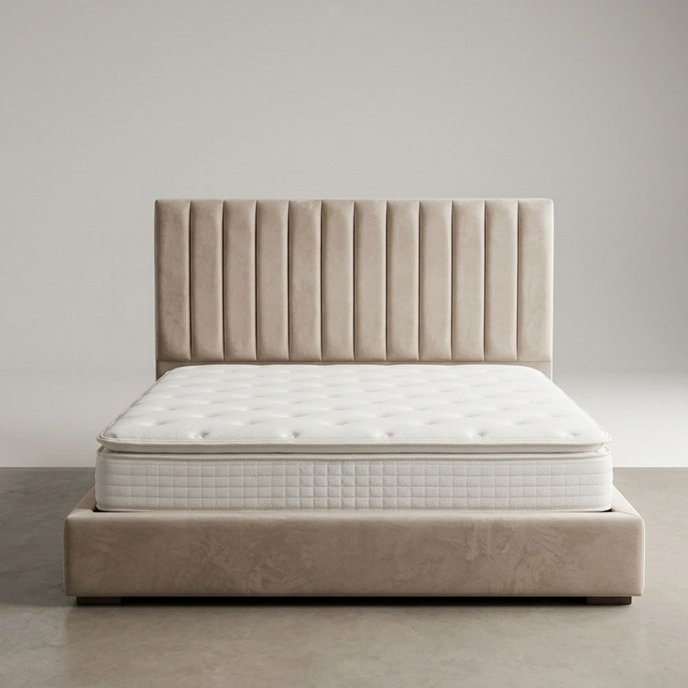 Beige bed with tufted headboard and mattress on a plain background