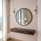 Round mirror with a wooden console table against a beige wall.