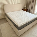 Beige bed with a mattress in a bedroom setting