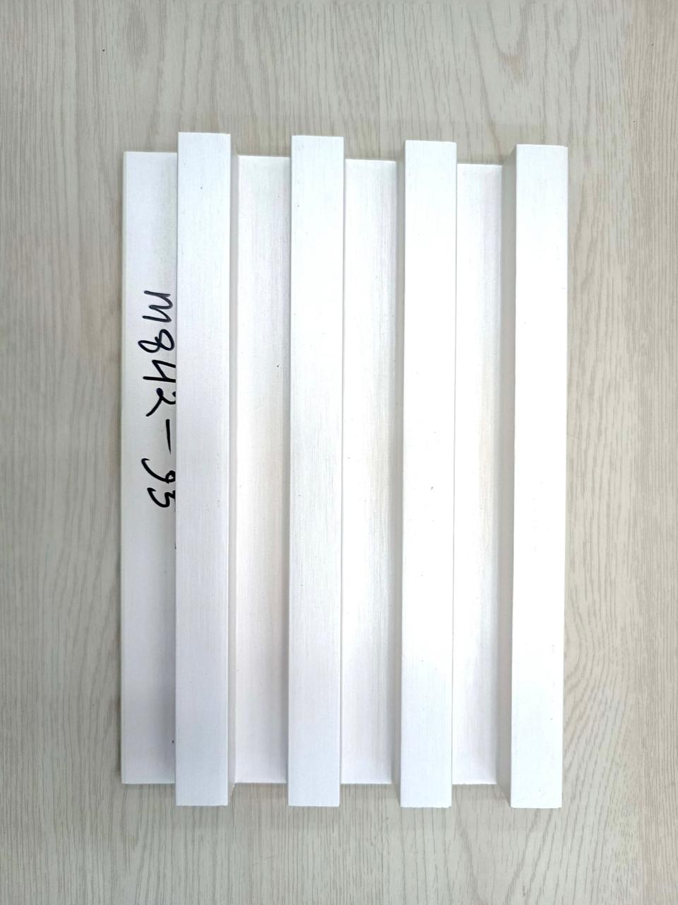 Set of white plastic strips with text on a wooden surface