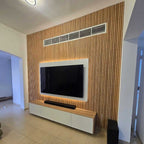Modern living room with a television mounted on a wooden wall.