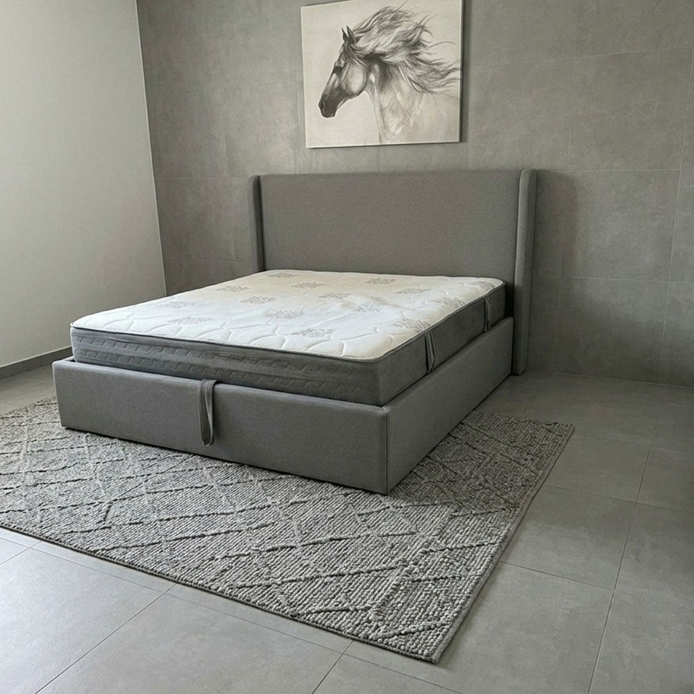 Gray bed frame with mattress in a room with a horse painting on the wall.