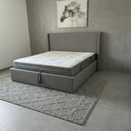 Gray bed frame with mattress in a room with a horse painting on the wall.