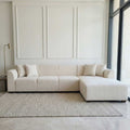 Beige sectional sofa in a modern living room with large windows.