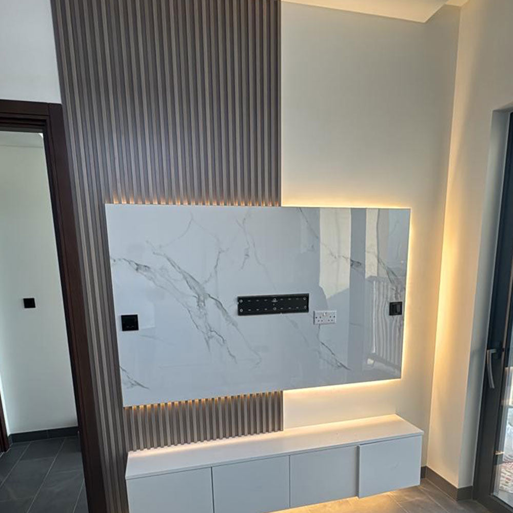 Modern kitchen setup with a marble-textured wall panel and built-in cabinets.