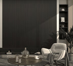 Modern living room with a black textured wall, white armchair, and decorative items.