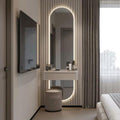 Modern bedroom with a vanity table, mirror, and television.
