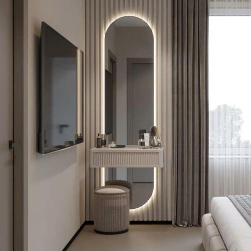 Modern bedroom with a vanity table, mirror, and television.